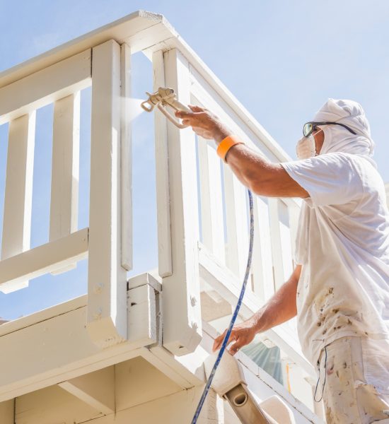 House Painter Spray Painting A Deck of A Home